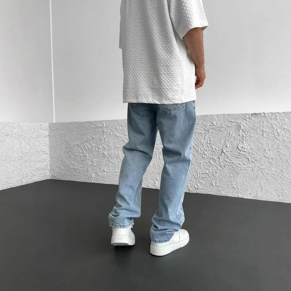 Men's blue straight-leg denim trousers with mid waist and zipper fly on neutral background