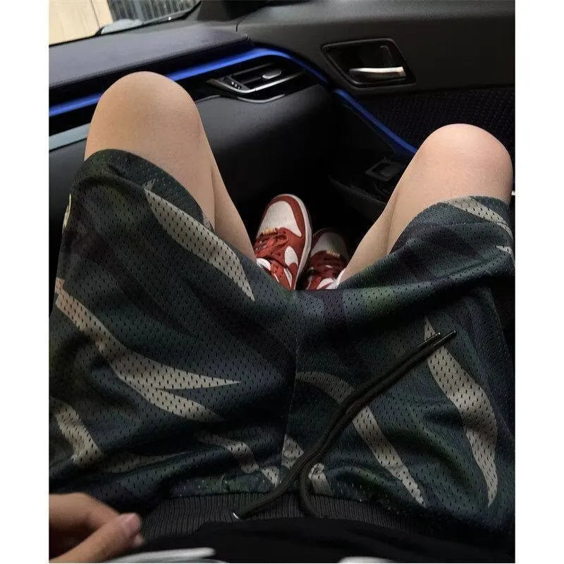 Men's camouflage mesh shorts with straight leg design on mannequin