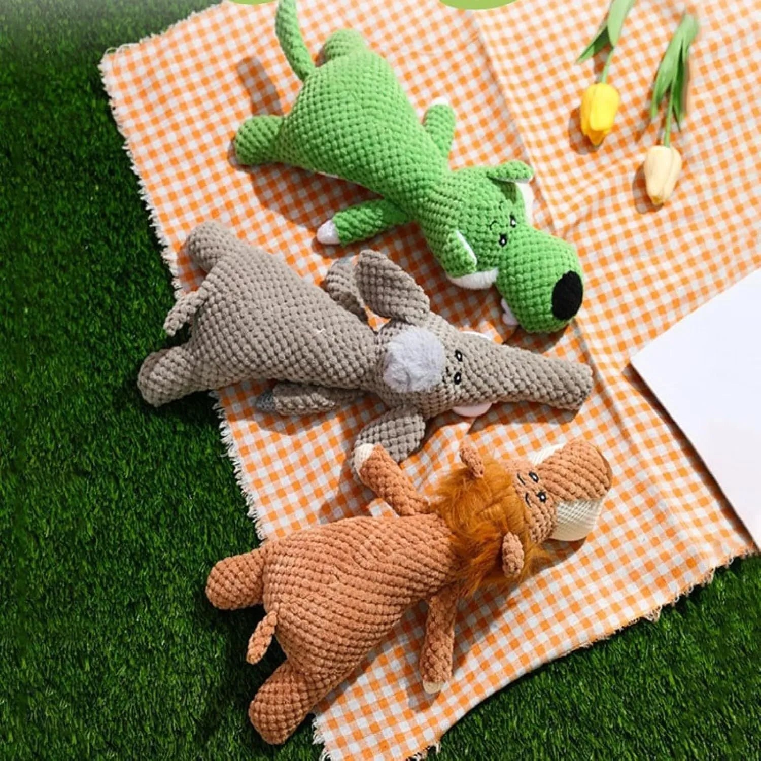 Grey plush dog toy shaped and textured like an ear of corn with visible kernels, lying on a plain surface.