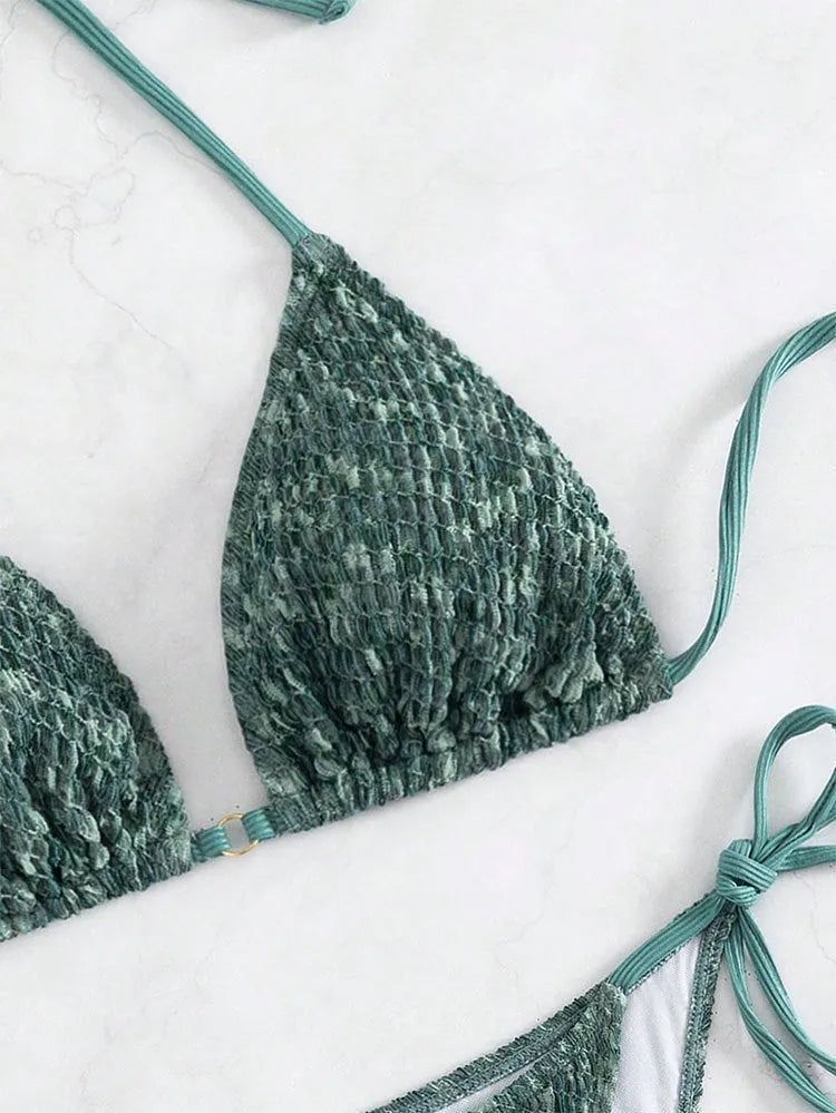 Green women's backless halter bikini set with shorts on a mannequin.