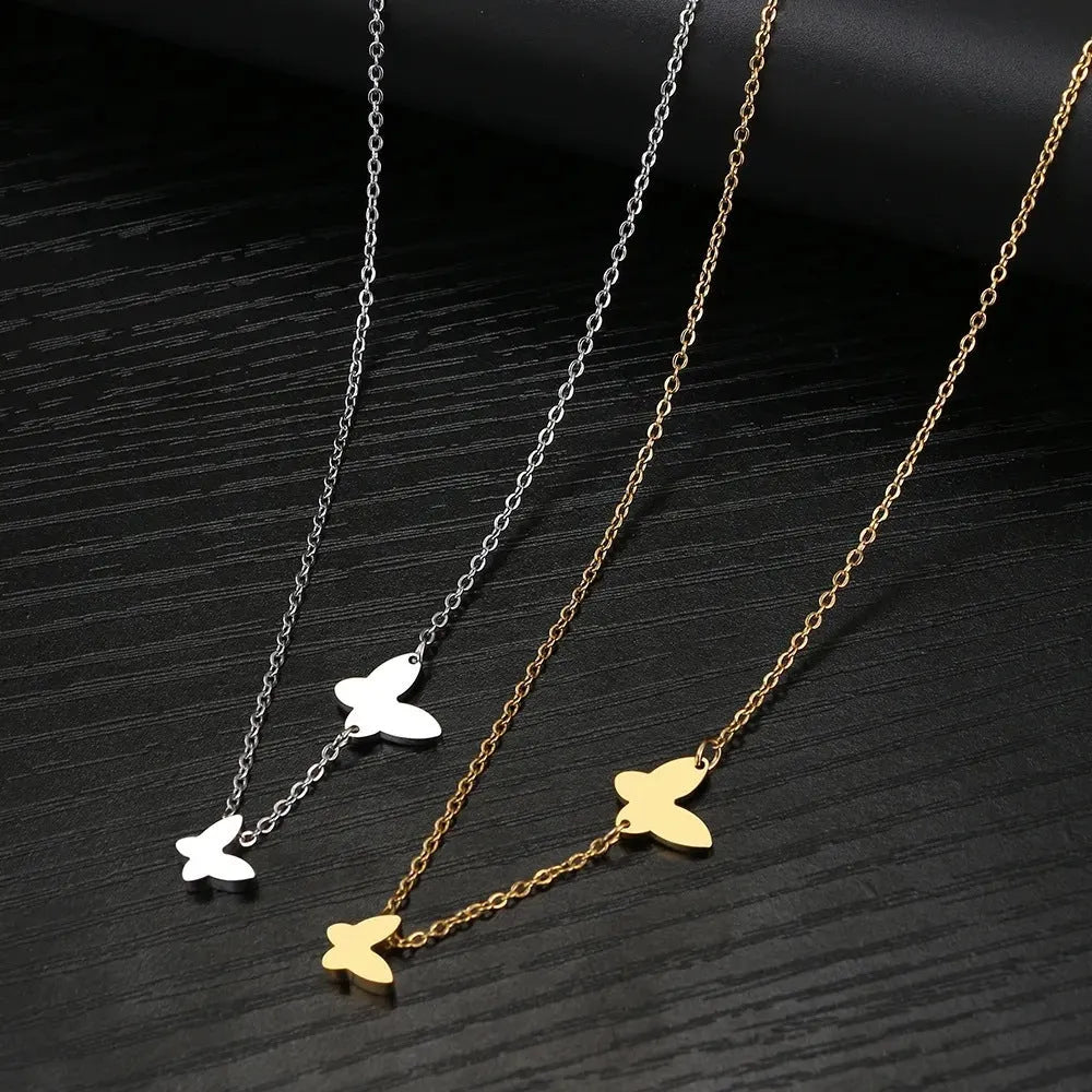 Butterfly pendant necklace in stainless steel with 18K gold electroplated finish on a white background