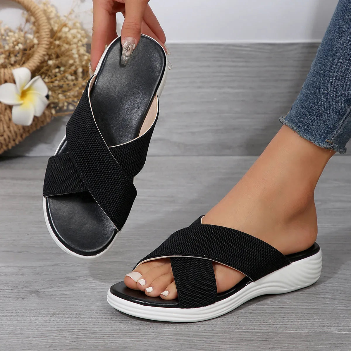 Women's black wedge slippers with cross-strap peep-toe design and thick rubber sole