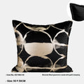Black and gold abstract print flannel decorative cushion pillow on a sofa.