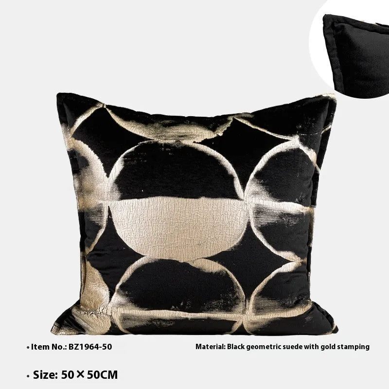 Black and gold abstract print flannel decorative cushion pillow on a sofa.