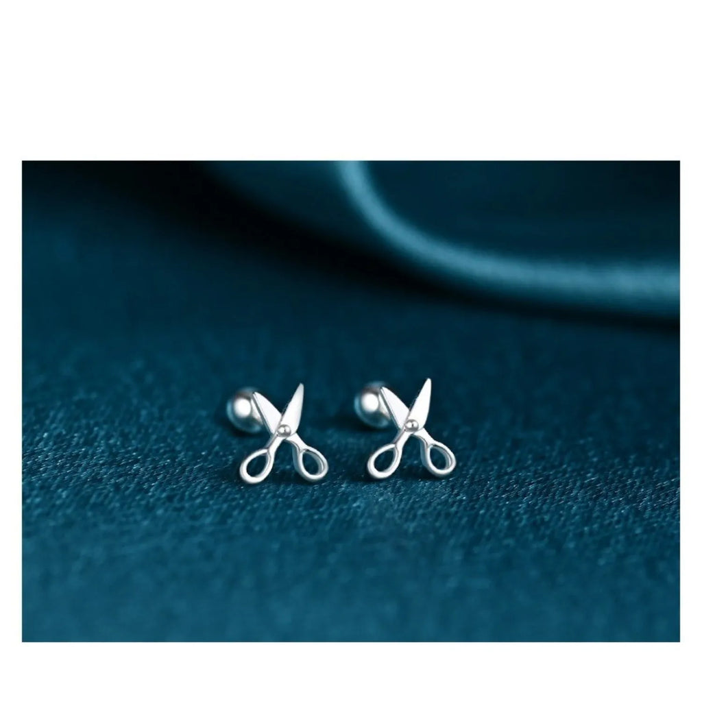 A pair of silver ear nail earrings with a mini scissors screw design and screw-back closures.