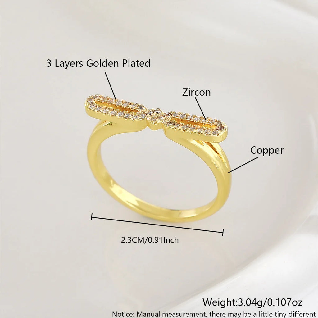 Fashion bowknot ring for women, copper with electroplated gold finish, bow shape on white background