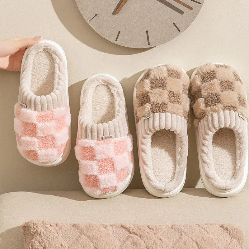 Women's plaid patterned plush slippers with non-slip sole in multiple colours on a wooden floor.