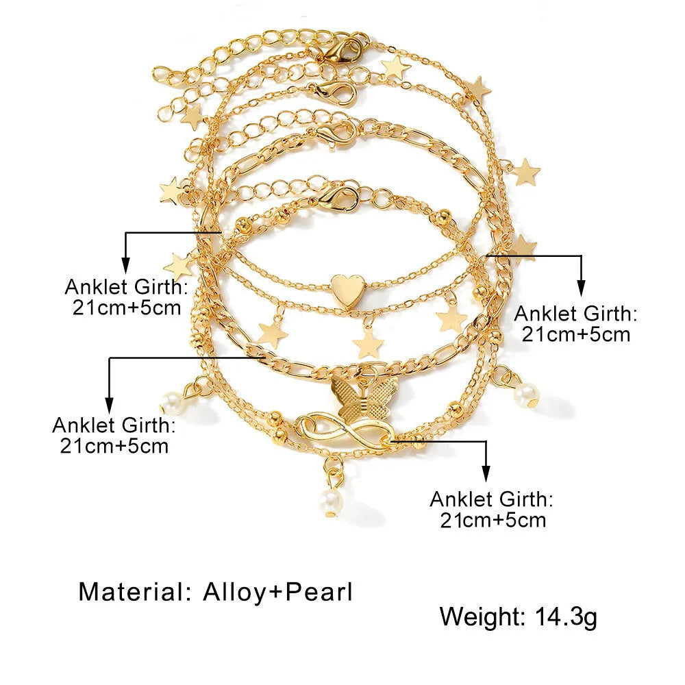 Four different alloy anklets with butterfly and pearl heart pendants arranged as a jewellery set