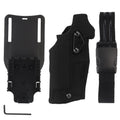 Left hand camouflage waist bag with leg warmer, black CP GB-87, against outdoor foliage background