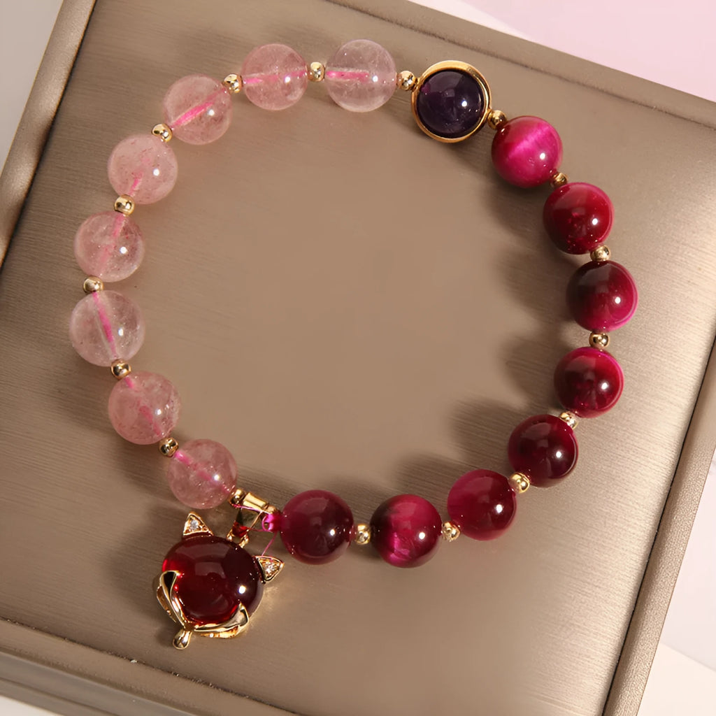 Simple bracelet with a red strawberry crystal on a black elastic rope.
