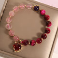 Simple bracelet with a red strawberry crystal on a black elastic rope.