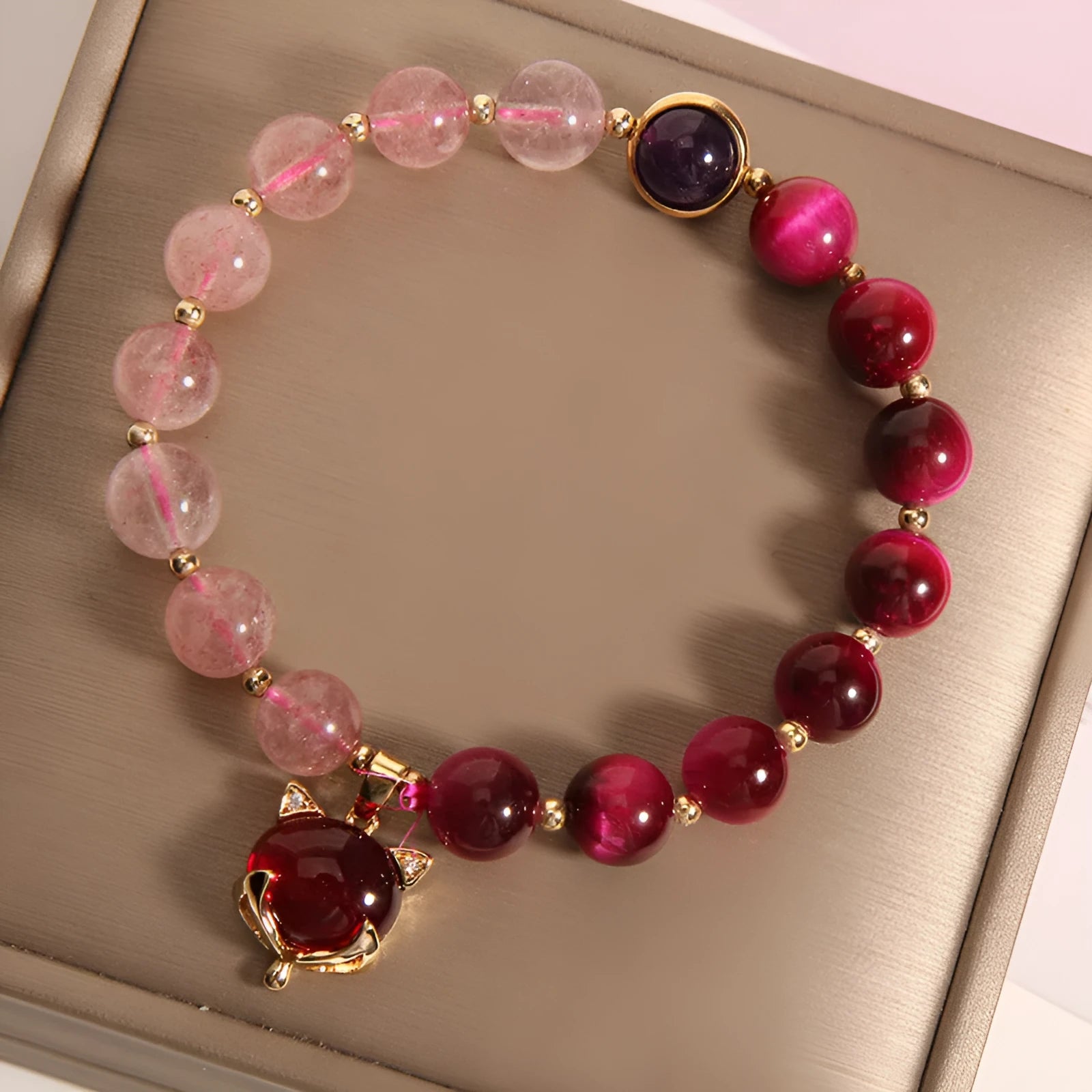 Simple bracelet with a red strawberry crystal on a black elastic rope.