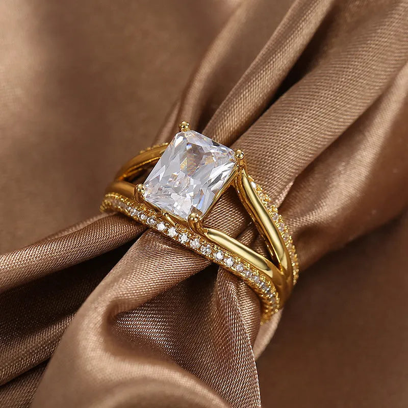 Geometric gold-coloured women's ring with a square zircon stone on a copper band.