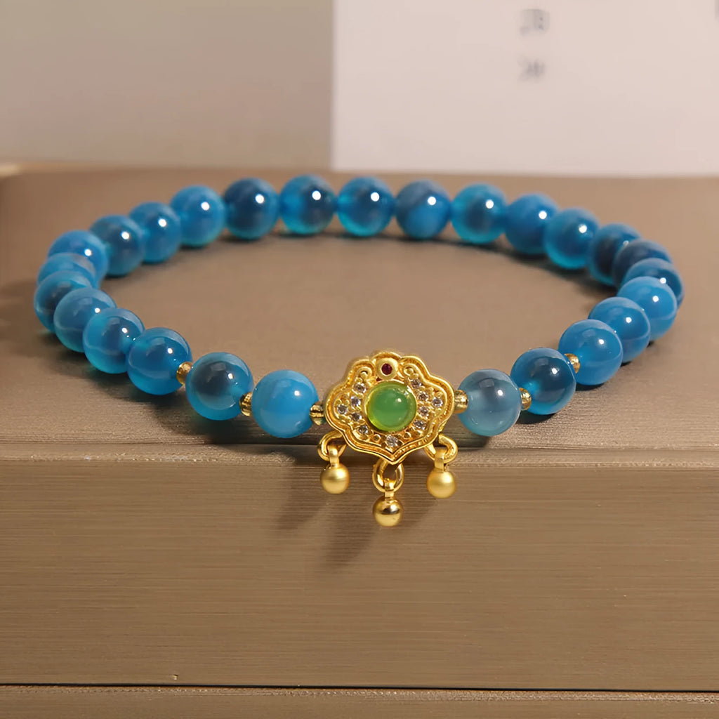 Blue agate safety lock pendant on a women's crystal bracelet with alloy-inlaid gemstones and rhinestones.