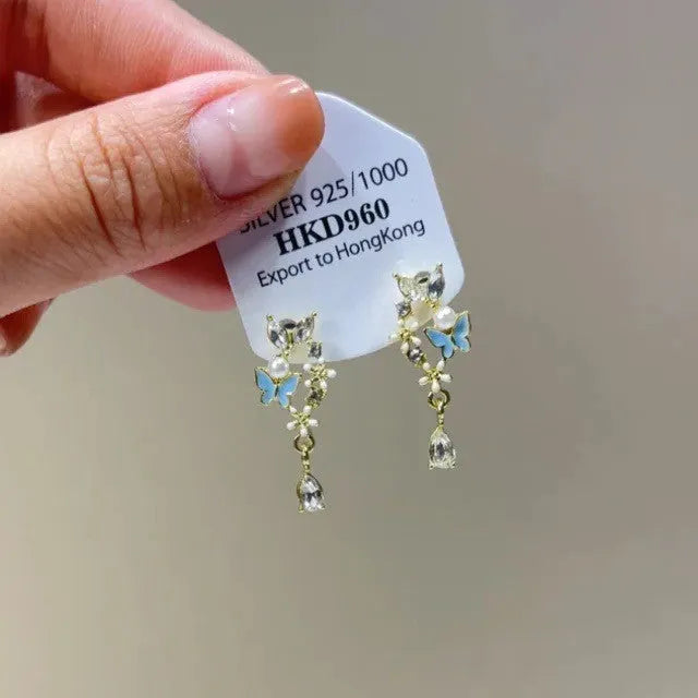 Silver geometric heart-shaped clip-on earrings with rhinestones and a dangling star tassel charm.