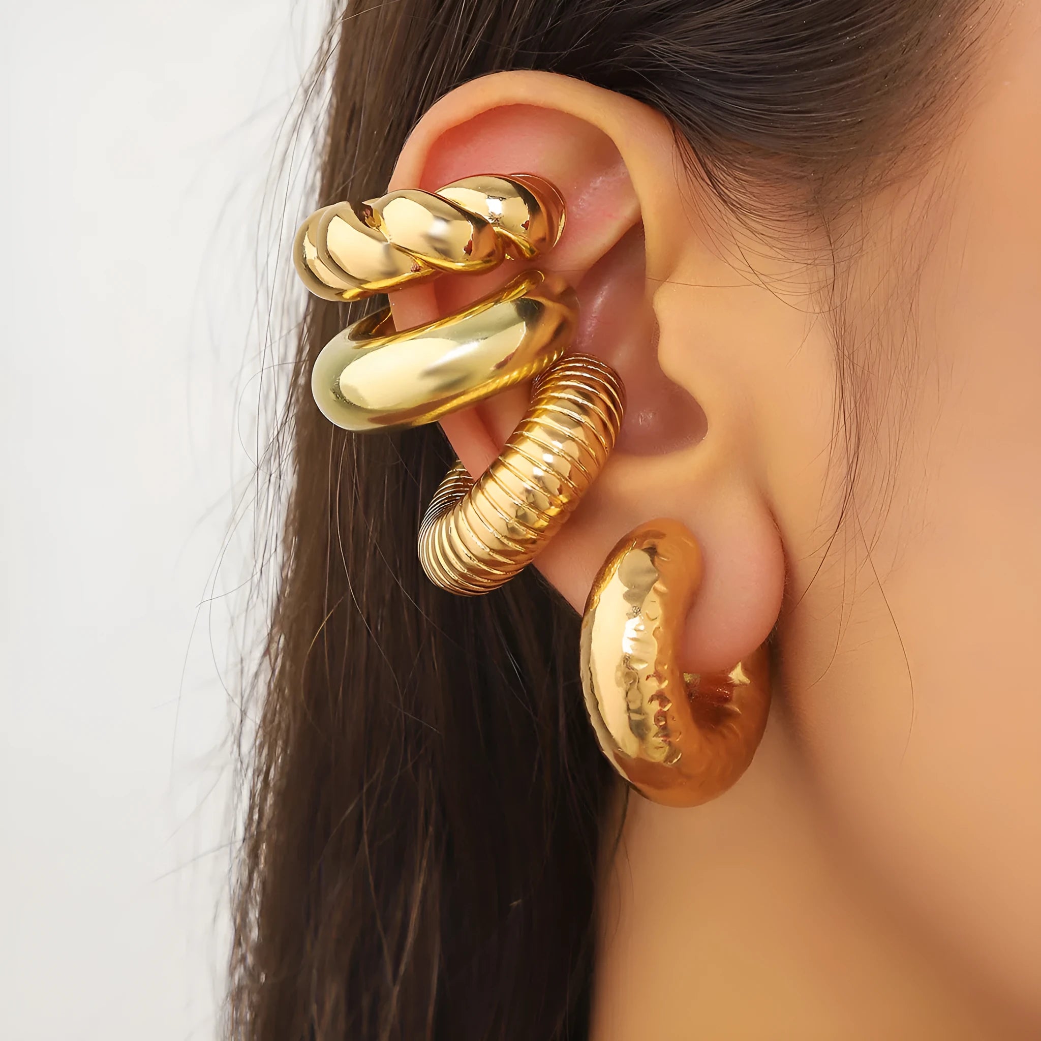 Geometric gold and silver ear clips for women without pierced ears showing exaggerated shape design
