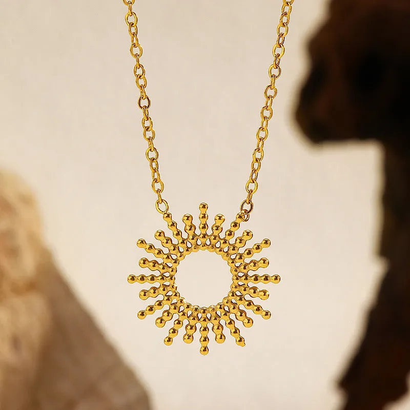 Women's gold geometric sunflower chain necklace and bracelet set on white background