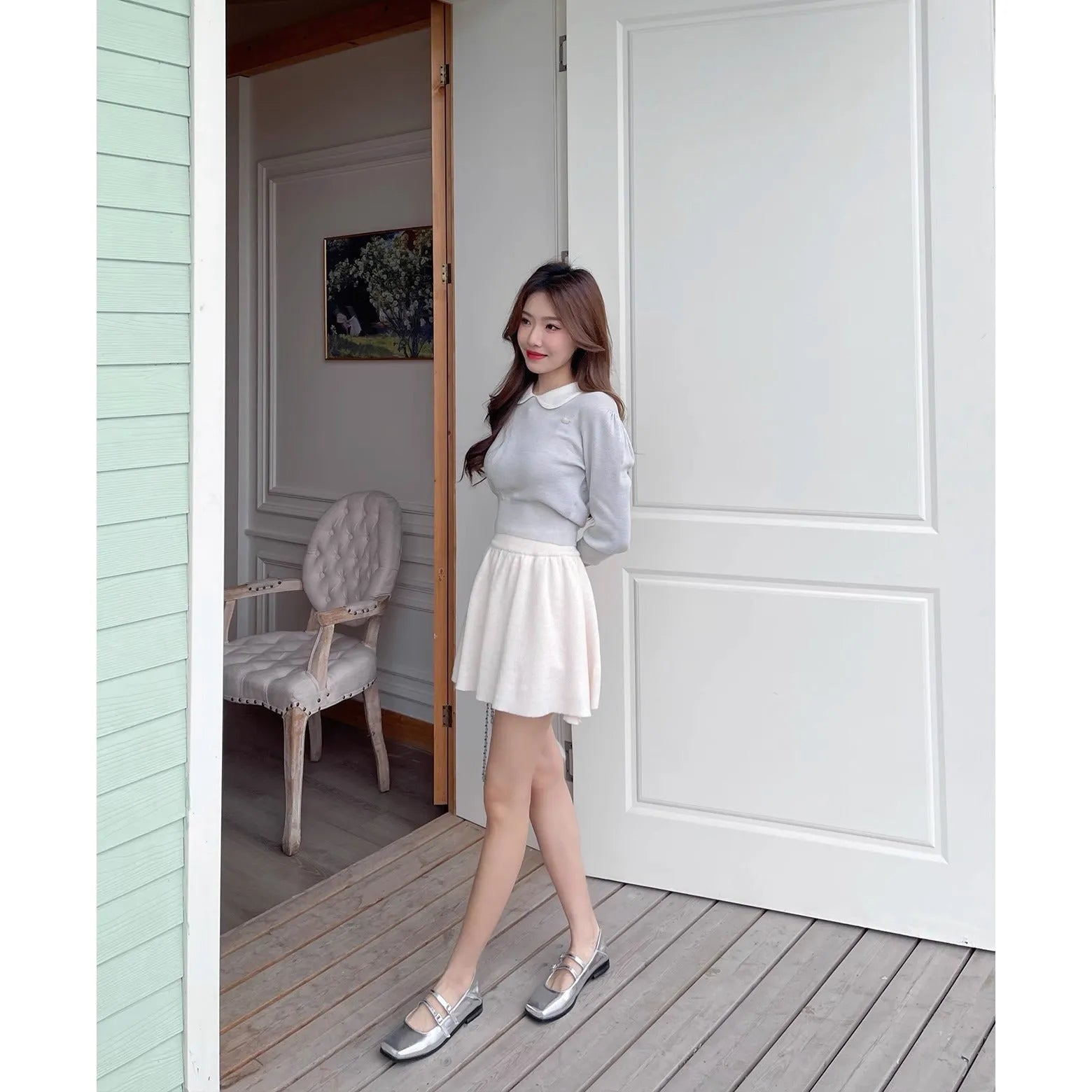 Women's silver leather ballet flats with a cross buckle strap over the instep and a flat sole.