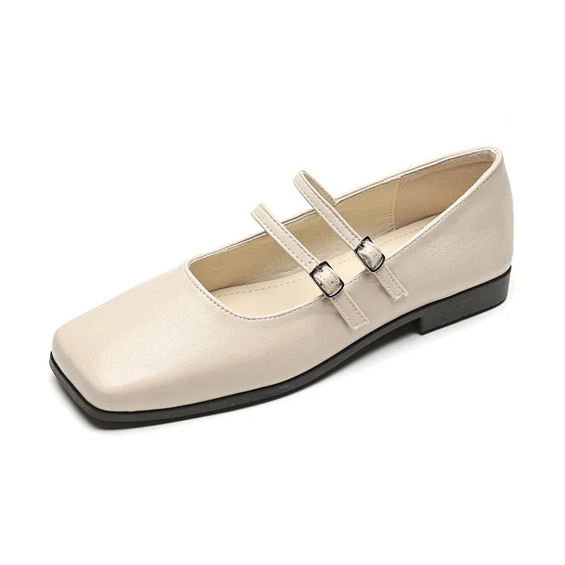 Women's silver leather ballet flats with a cross buckle strap over the instep and a flat sole.