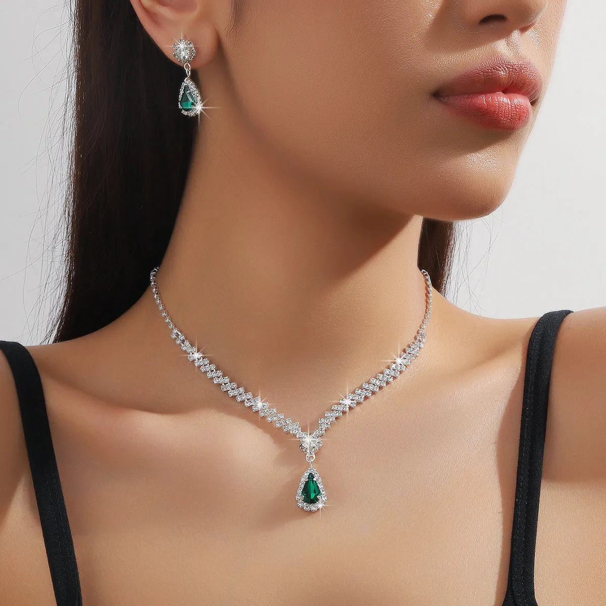 Claw chain necklace and matching drop earrings set with rhinestones in multiple colours.