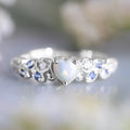 White electroplated alloy women's ring with a heart shape, featuring peach opal and ocean heart design details.