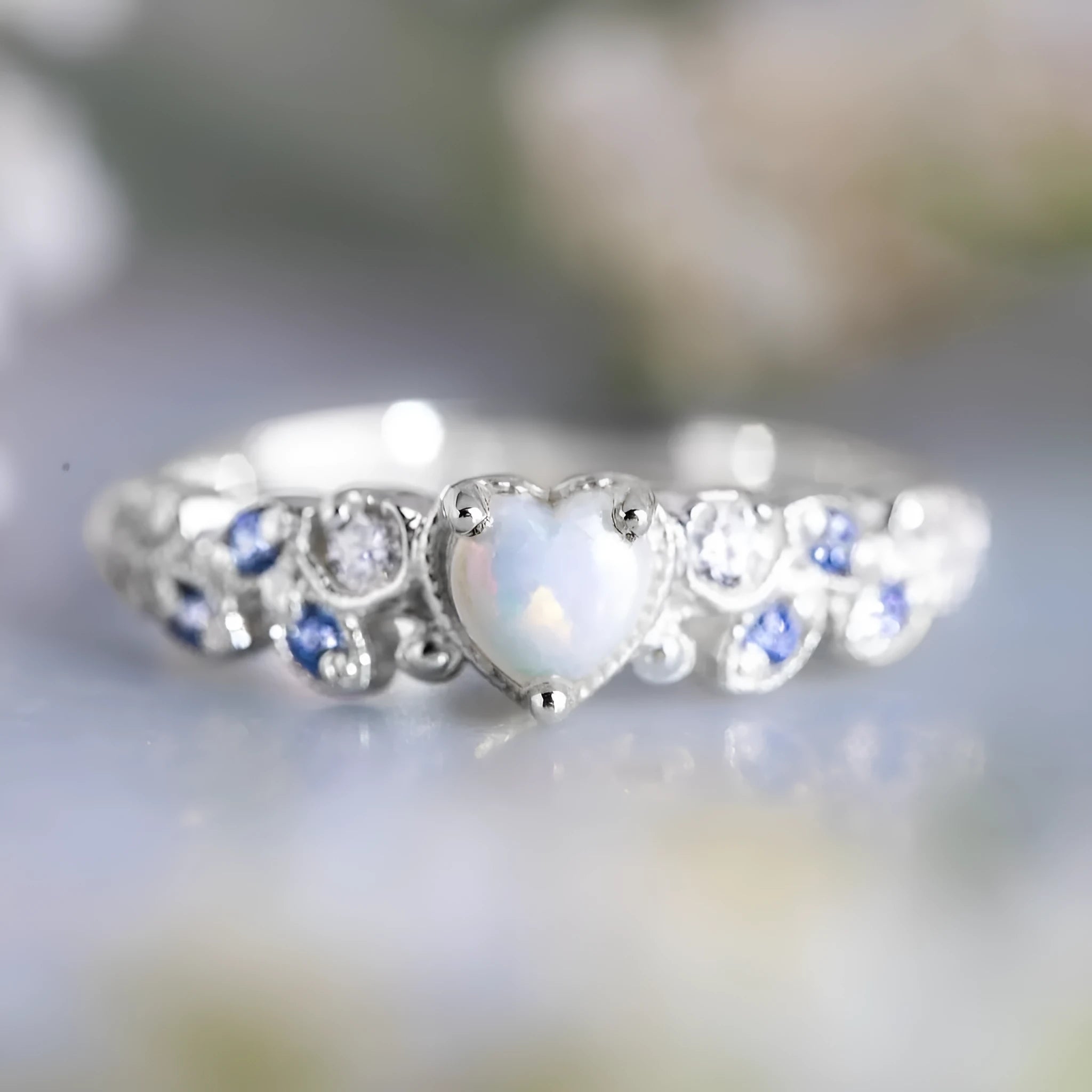 White electroplated alloy women's ring with a heart shape, featuring peach opal and ocean heart design details.