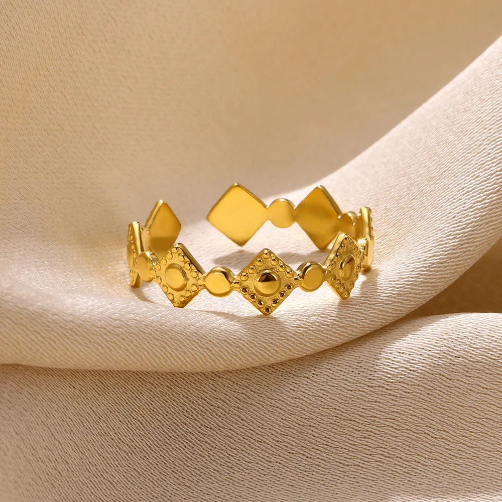 Gold coloured titanium steel women's ring with geometric shape and large diamond stone.