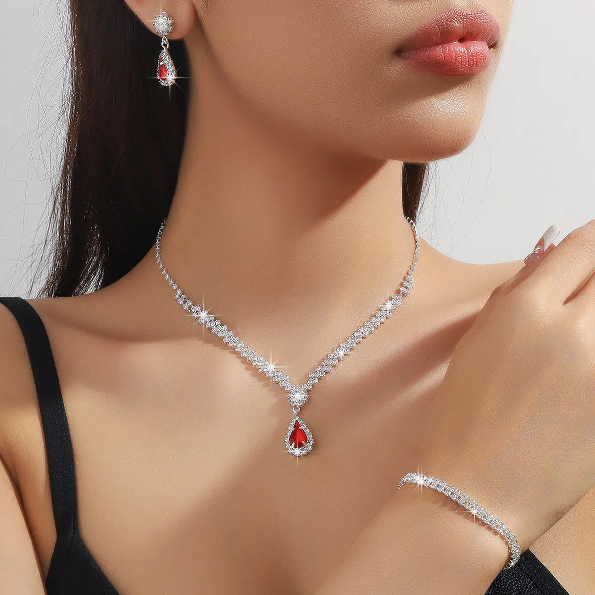 Claw chain necklace and matching drop earrings set with rhinestones in multiple colours.