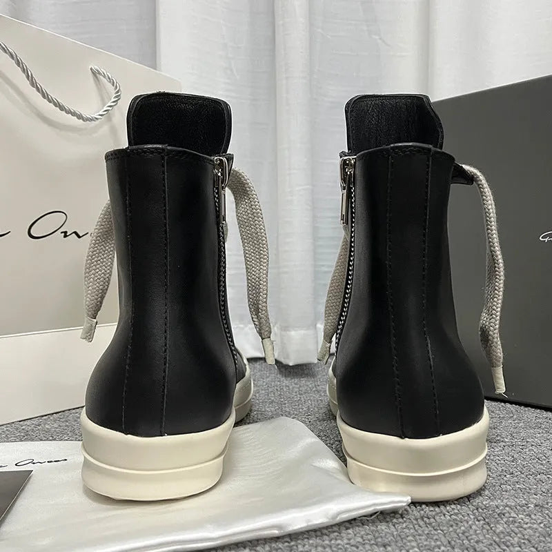 Black high-top leather unisex sneakers with a side zipper on a white background.