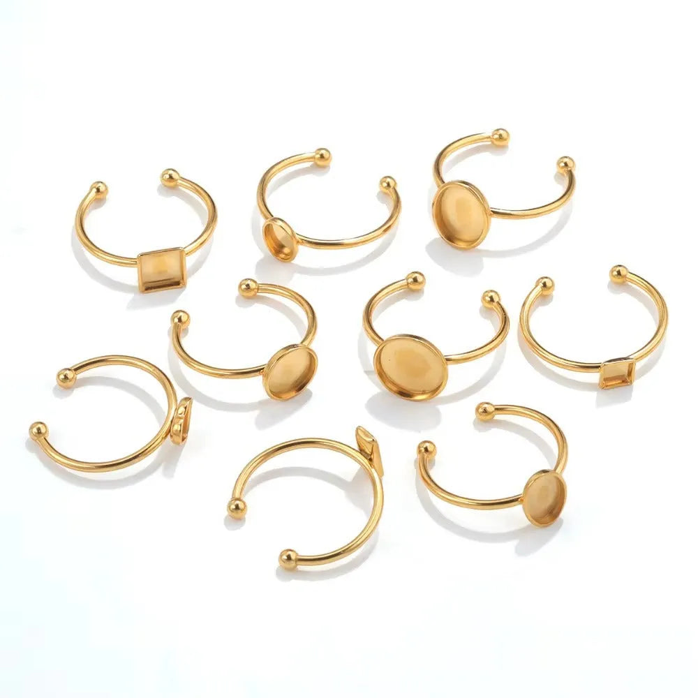 Golden stainless steel ring settings in various shapes including oval, round, square, rectangle, and heart designs