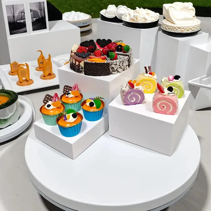 Set of six white plastic cube units forming a tiered desktop dessert display stand.