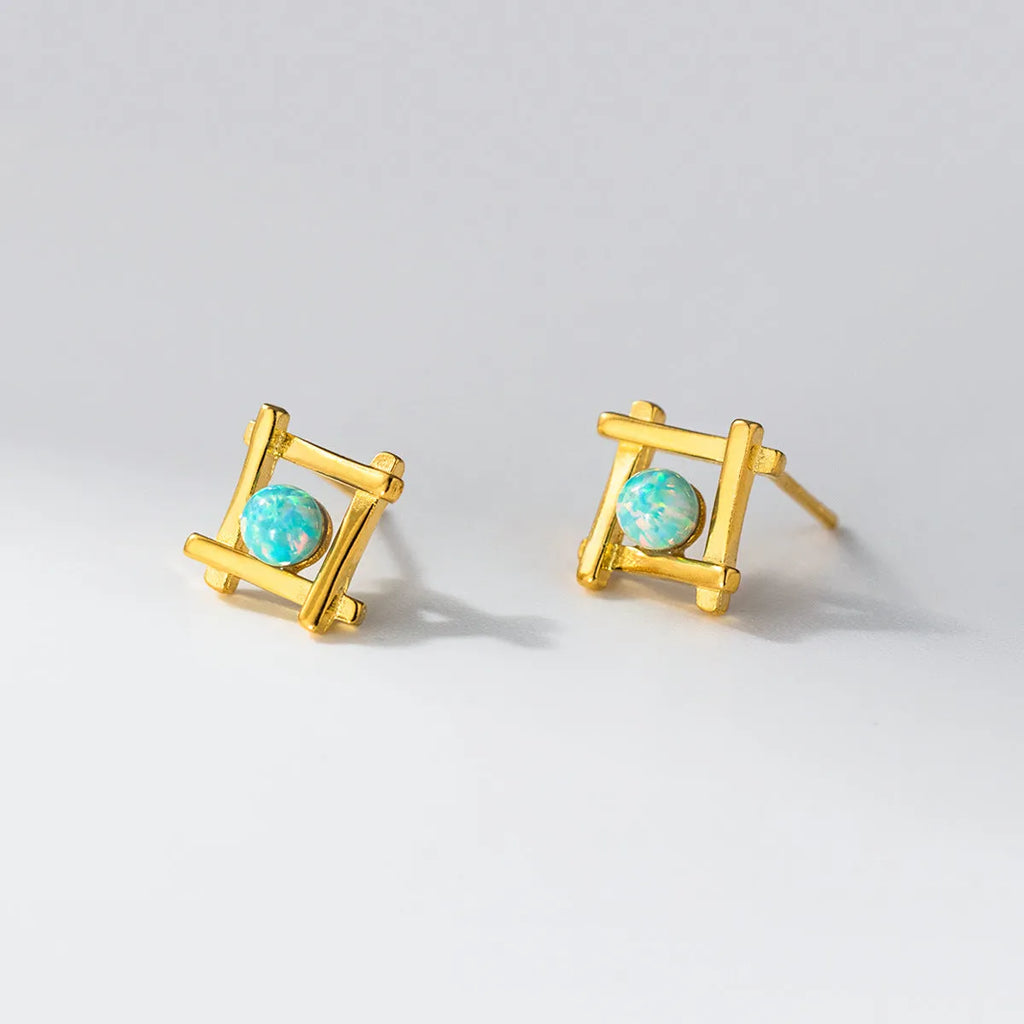 Geometric cross-shaped silver stud earrings for women on a white background.