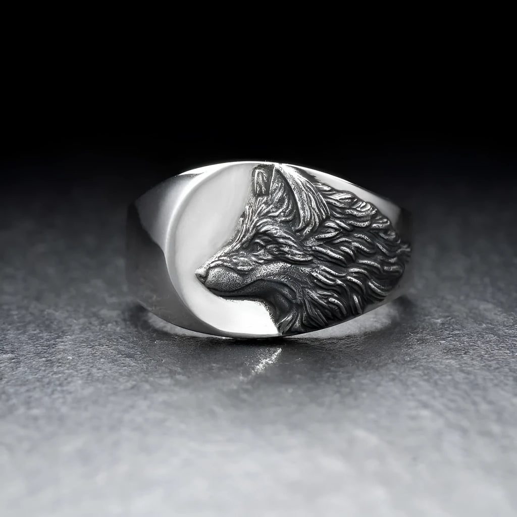 Silver geometric wolf head men's ring on a dark background, showing angular design details.