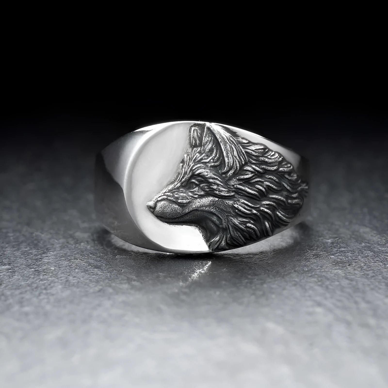 Silver geometric wolf head men's ring on a dark background, showing angular design details.