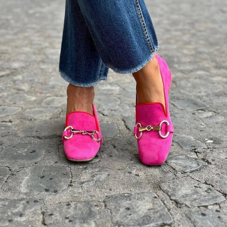 Green flat bottom loafers with a round toe and metal fastener on the front.