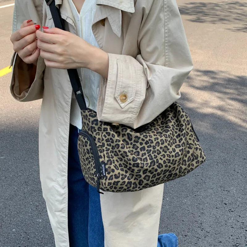 Sports style messenger bag in leopard print pattern with visible stitching and cross-body strap