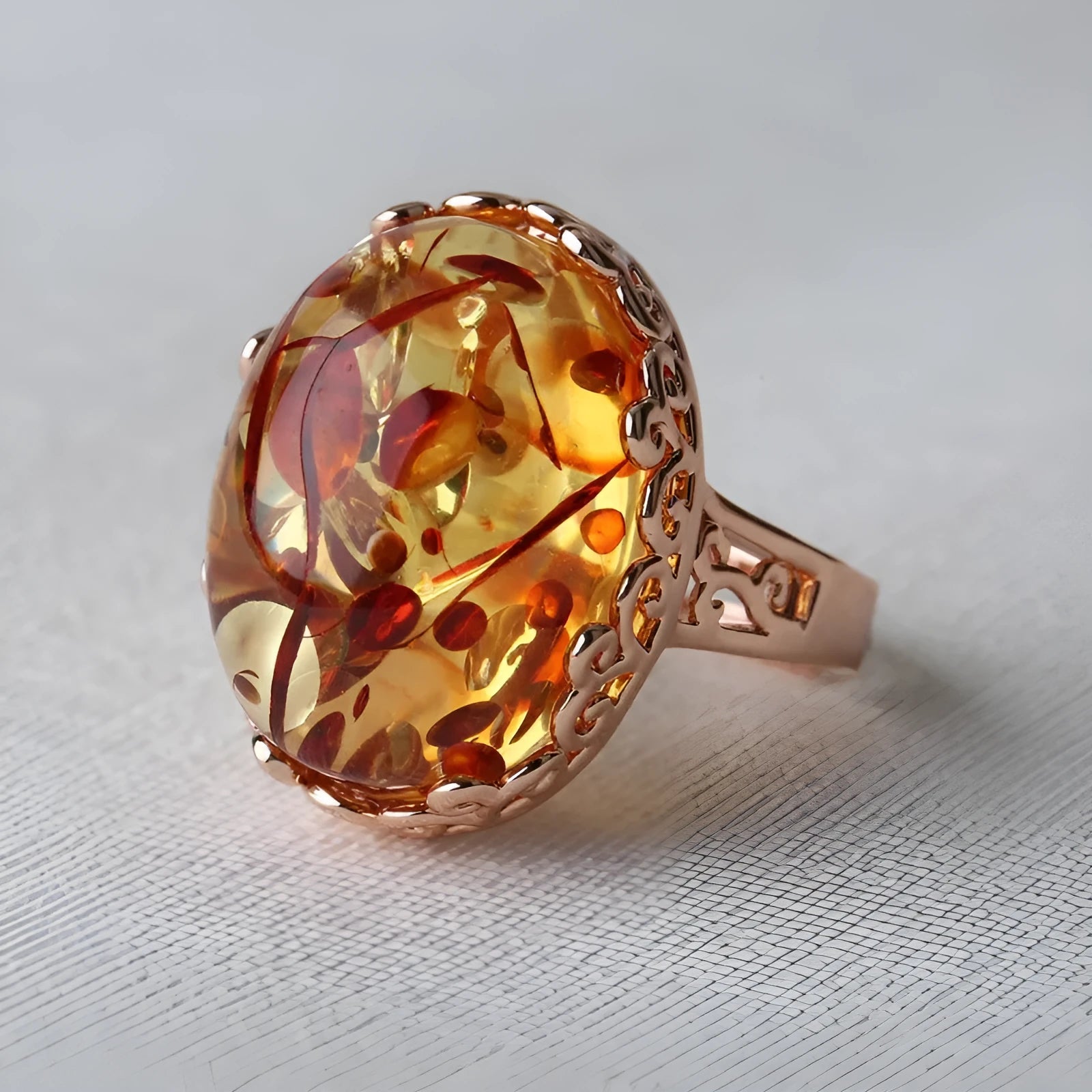 Close-up of a retro-style amber ring with beeswax inclusion, in New Amber Type A colour, on an alloy band.