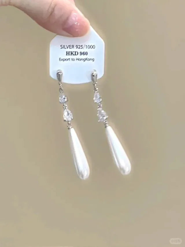 Silver geometric heart-shaped clip-on earrings with rhinestones and a dangling star tassel charm.