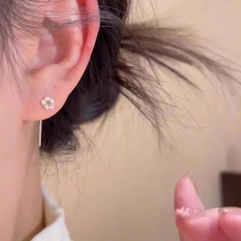 Silver flower stud earrings with hollow petal designs on alloy posts for women