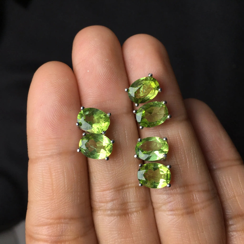 Natural grass green olivine faceted stud earrings in S925 sterling silver on a white background.