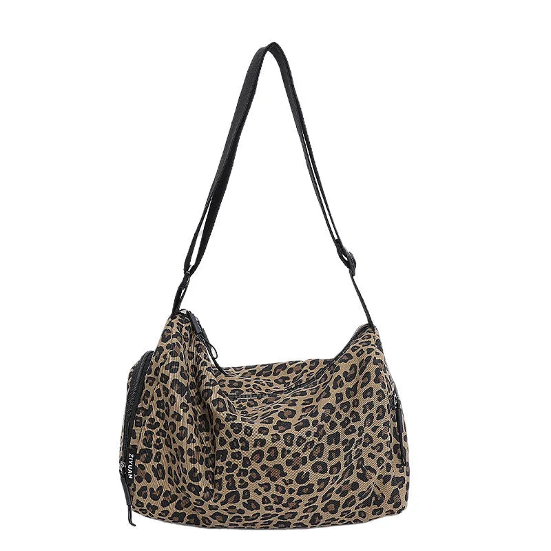 Sports style messenger bag in leopard print pattern with visible stitching and cross-body strap