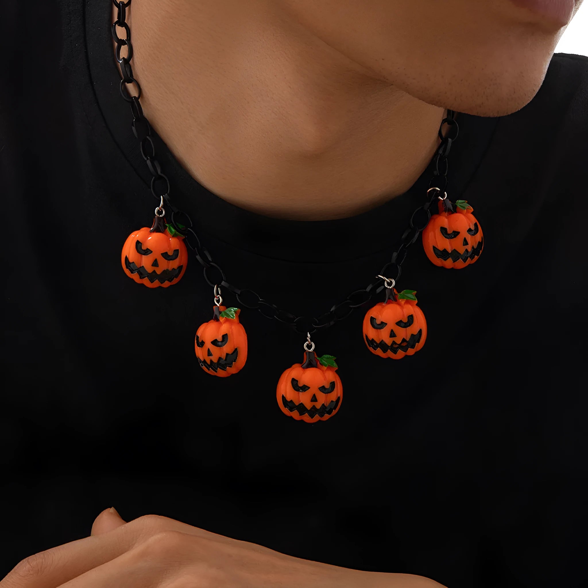 Halloween necklace showing a cartoon ghost and pumpkin acrylic pendant on a metal chain, in mixed colours.