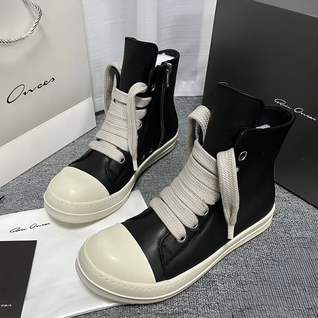 Black high-top leather unisex sneakers with a side zipper on a white background.