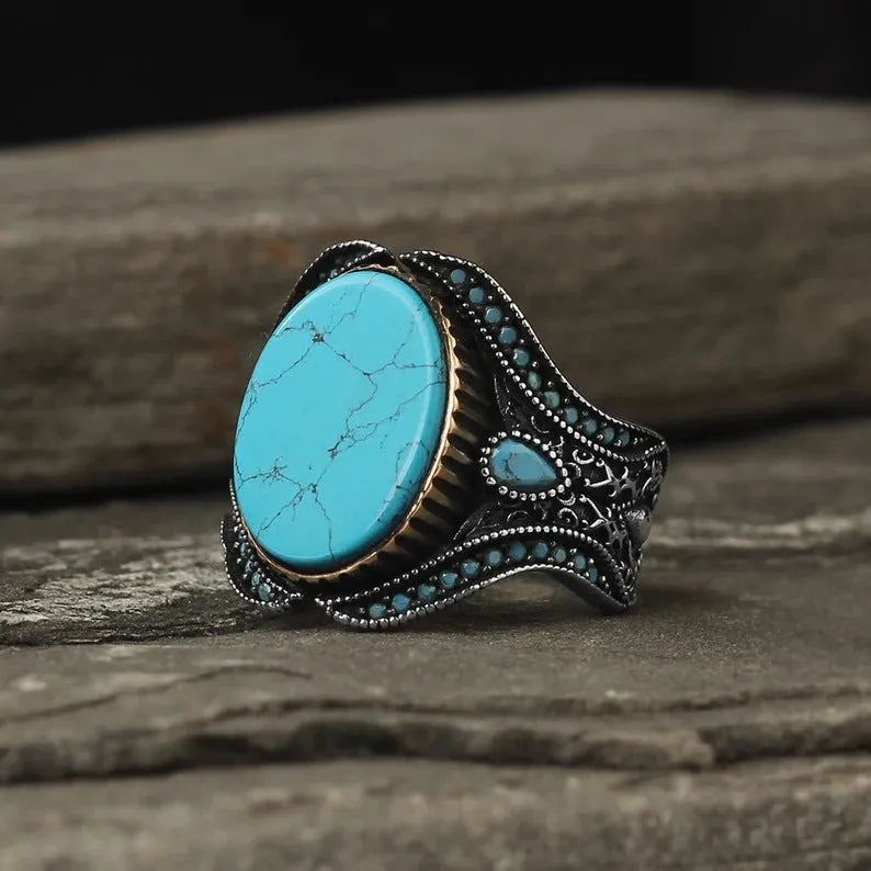 Round turquoise men's ring with antique silver alloy band showing stone detail and metallic finish