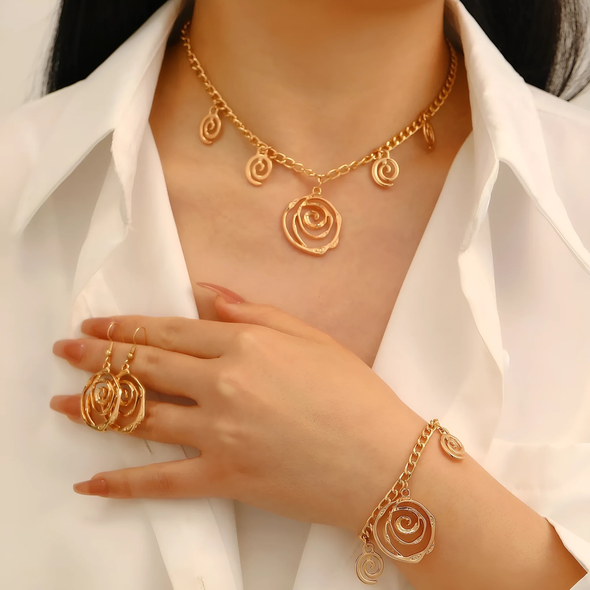Women's spiral donut jewellery set showing necklace, bracelet and earrings in gold alloy finish