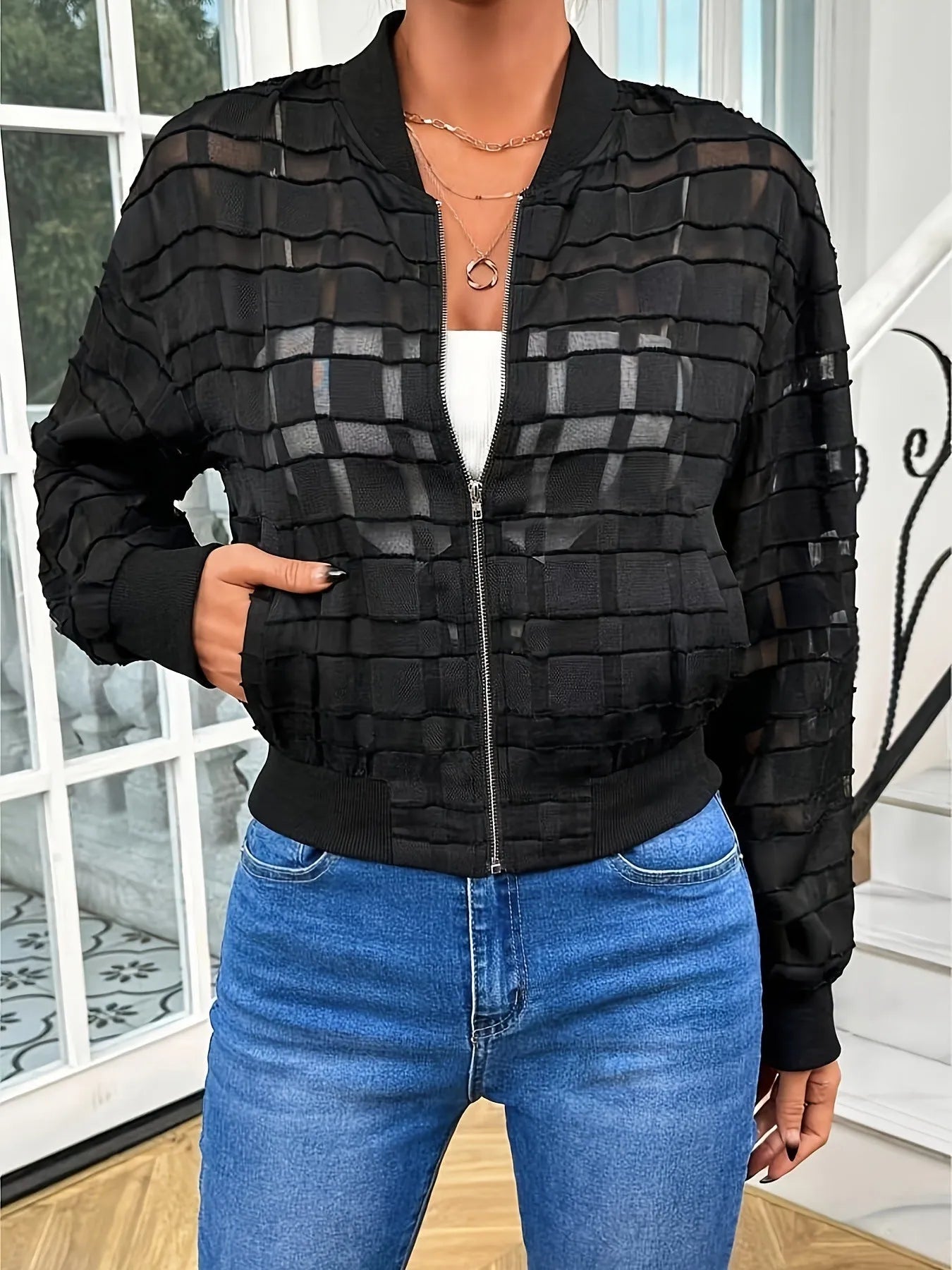 Black women's semi-transparent jacket with geometric pattern and front zipper.
