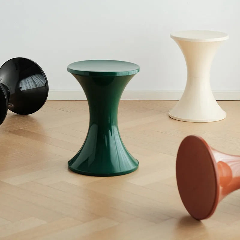 Hourglass-shaped plastic stool in green for changing shoes, used by an adult and child.
