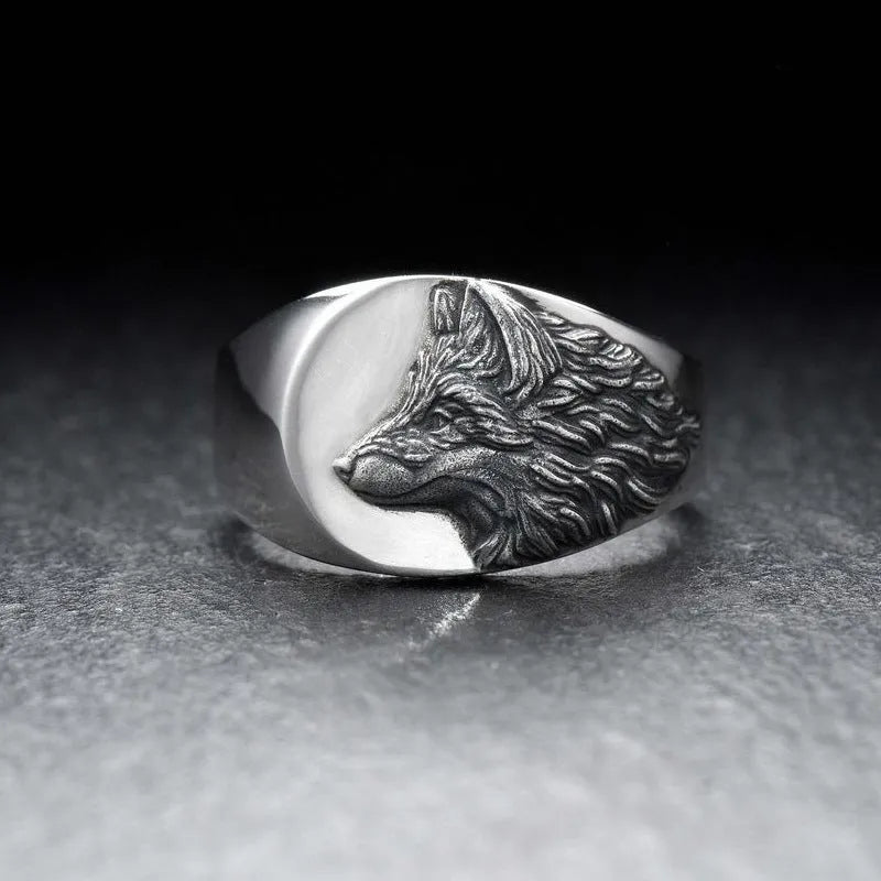 Silver geometric wolf head men's ring on a dark background, showing angular design details.
