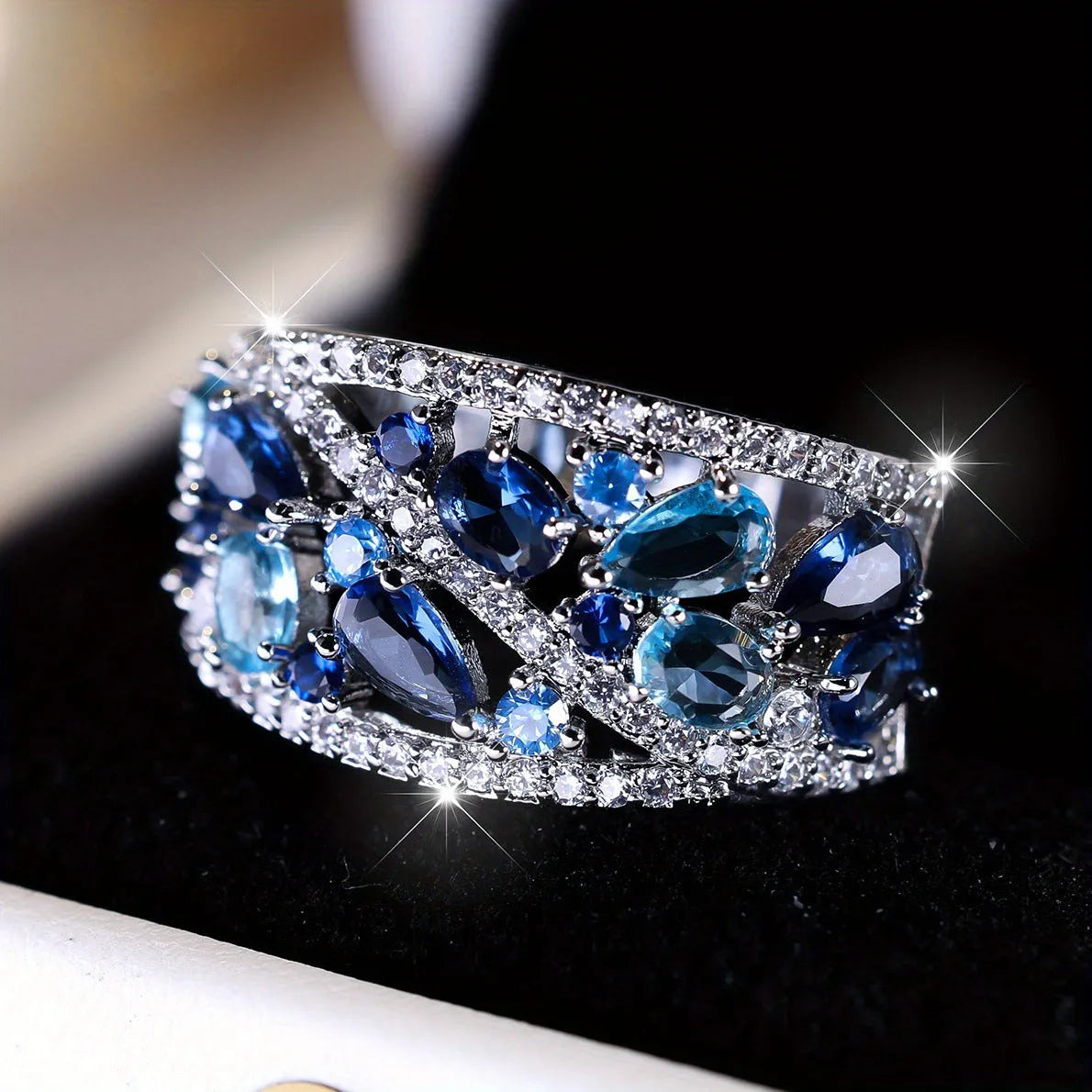 Women's round hollow copper ring with gemstone accents in gold or platinum plating with white or blue stones