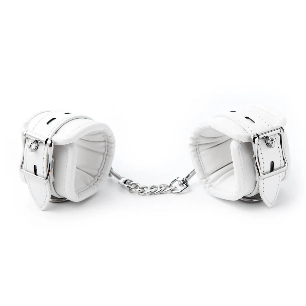 White PU sponge bondage restraint set showing handcuffs, footcuffs, and a neck collar.
